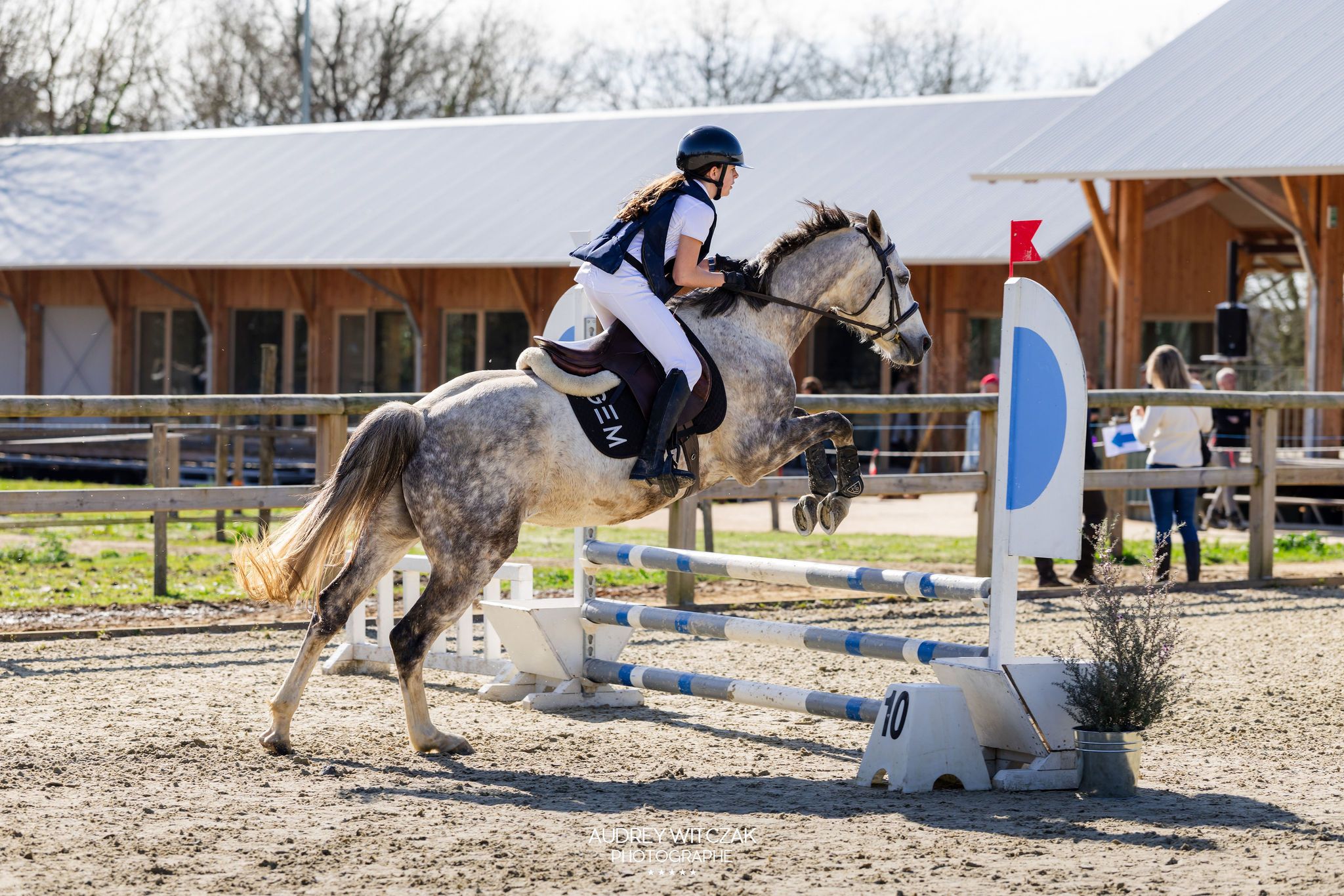 Une cavalière saute un obstacle pendant un concours